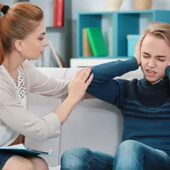 Terapeutaka wspierająca nastolatka z depresją, który zakrywa uszy.